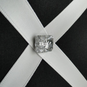 Close up of black fabric covered wall organiser with diamante button finish